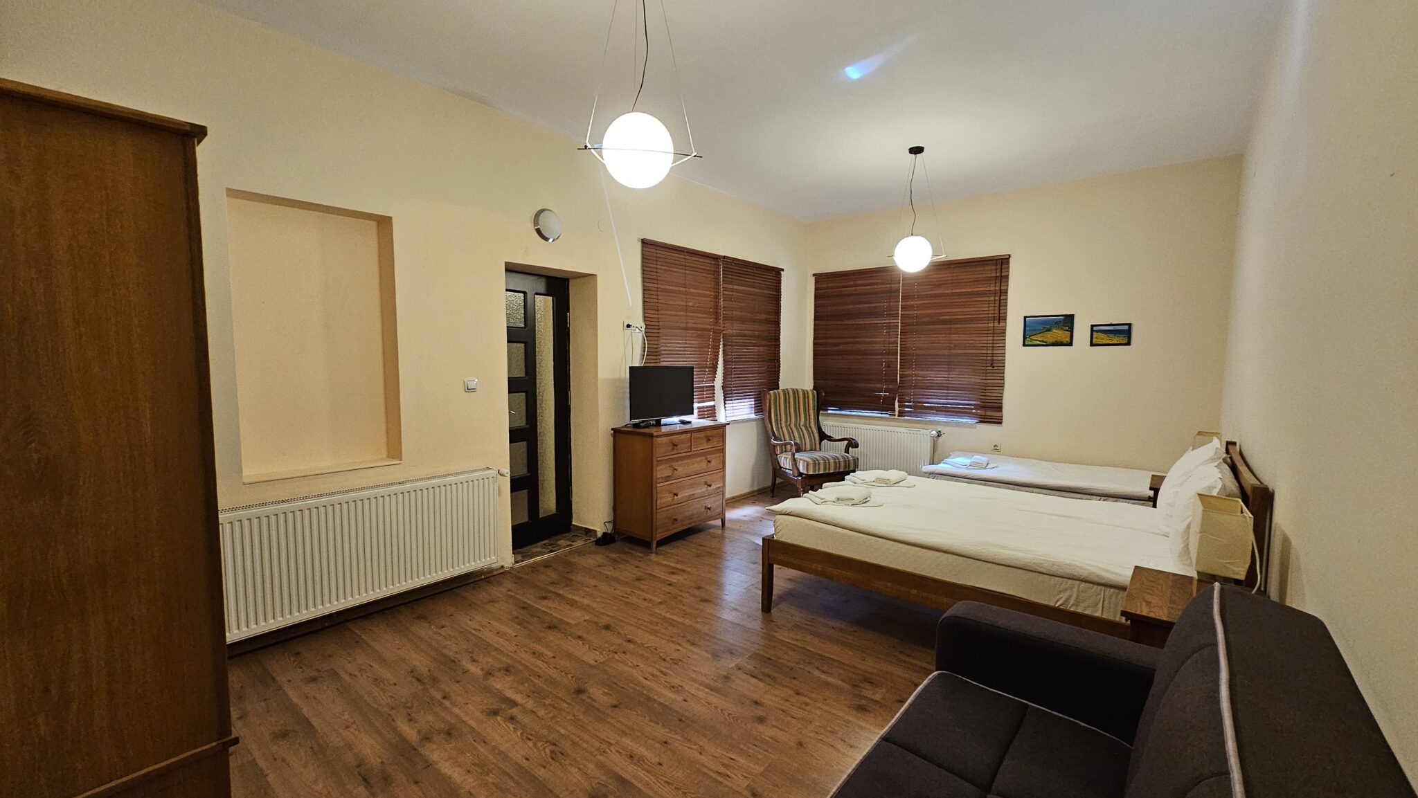 Chest of drawers with a television facing the beds, wooden blinds