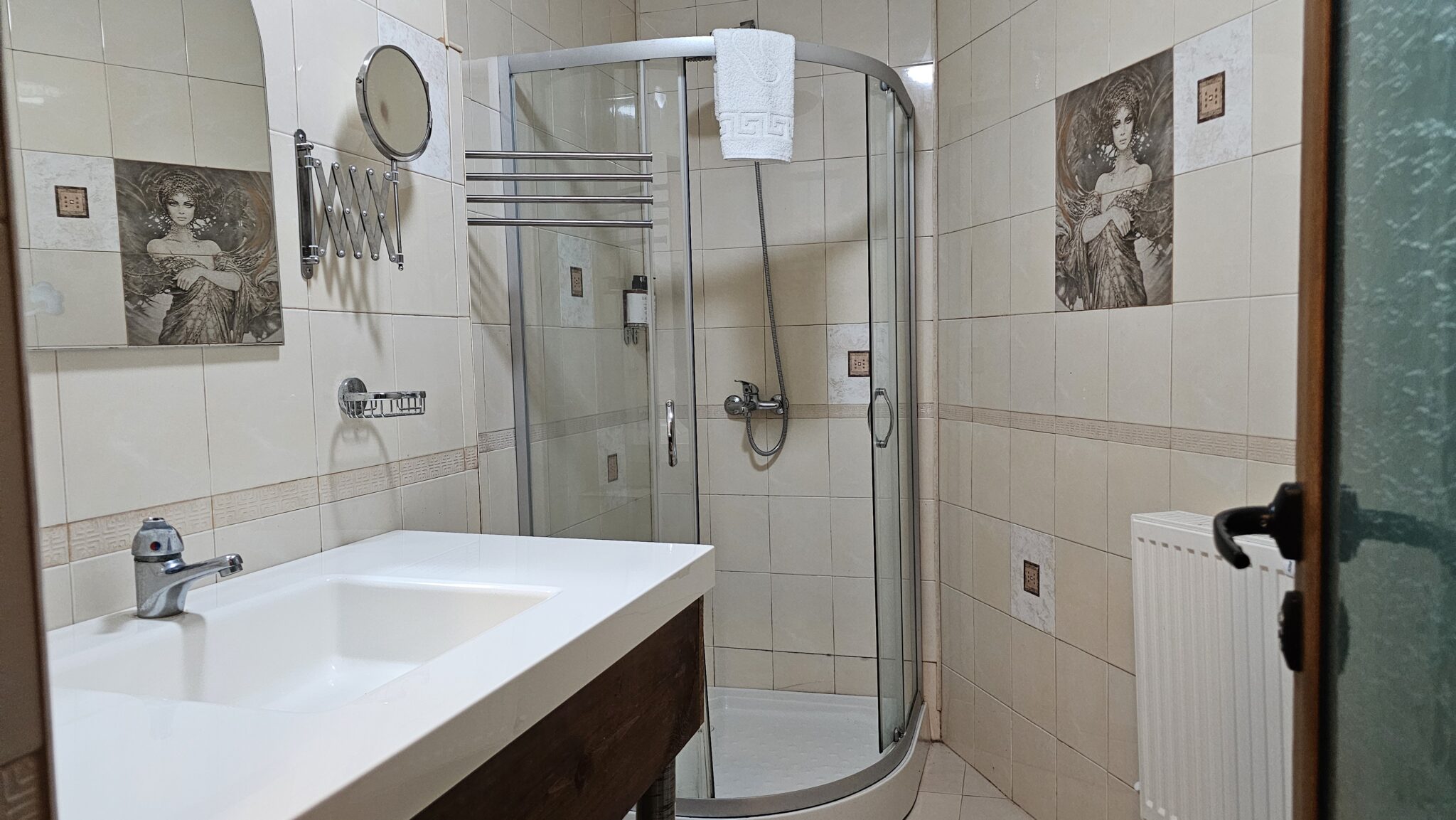 The bathroom: corner shower cabin and a washbasin