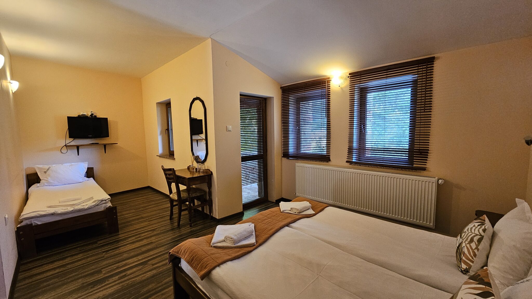 The double and single beds, dressing table with mirror and balcony door