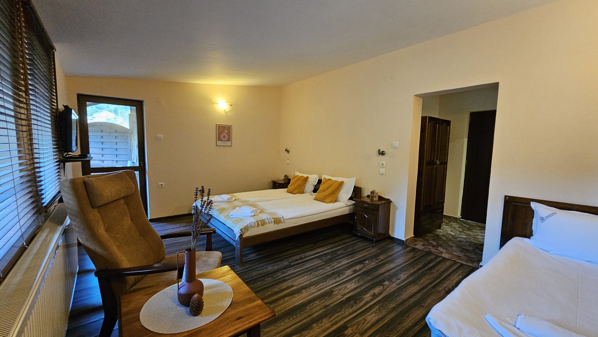 The room from the balcony door — bed, armchair and the bathroom entrance