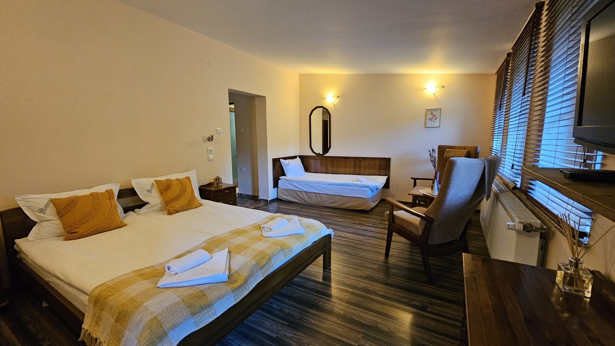 Double bed with a yellow cover, the single bed behind it