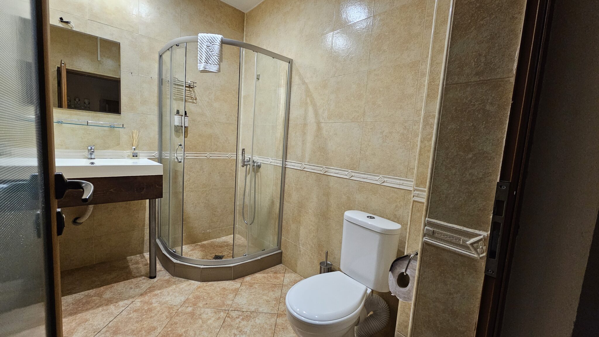 The bathroom: corner shower cabin, washbasin and toilet
