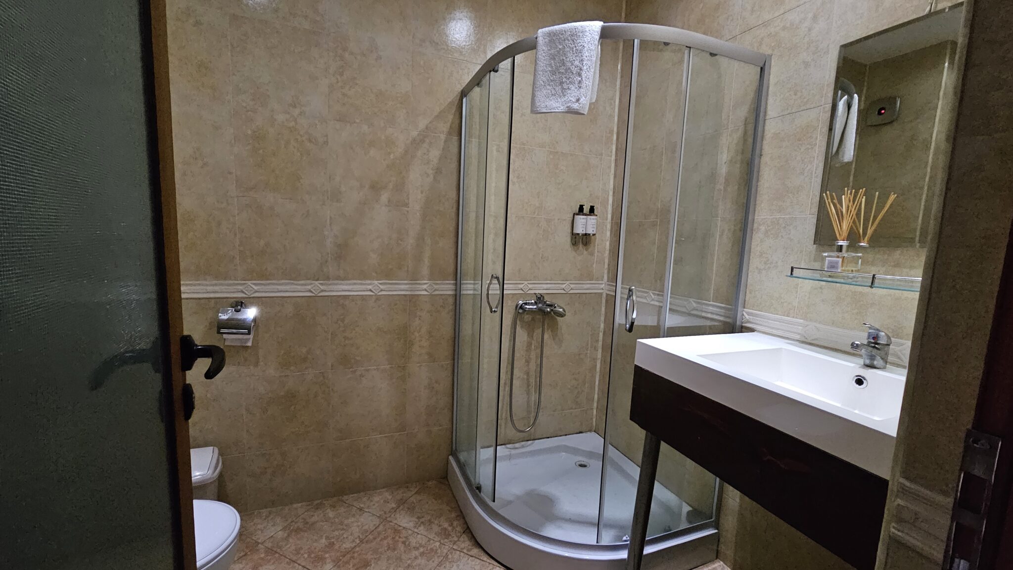 The bathroom: corner shower cabin and a washbasin