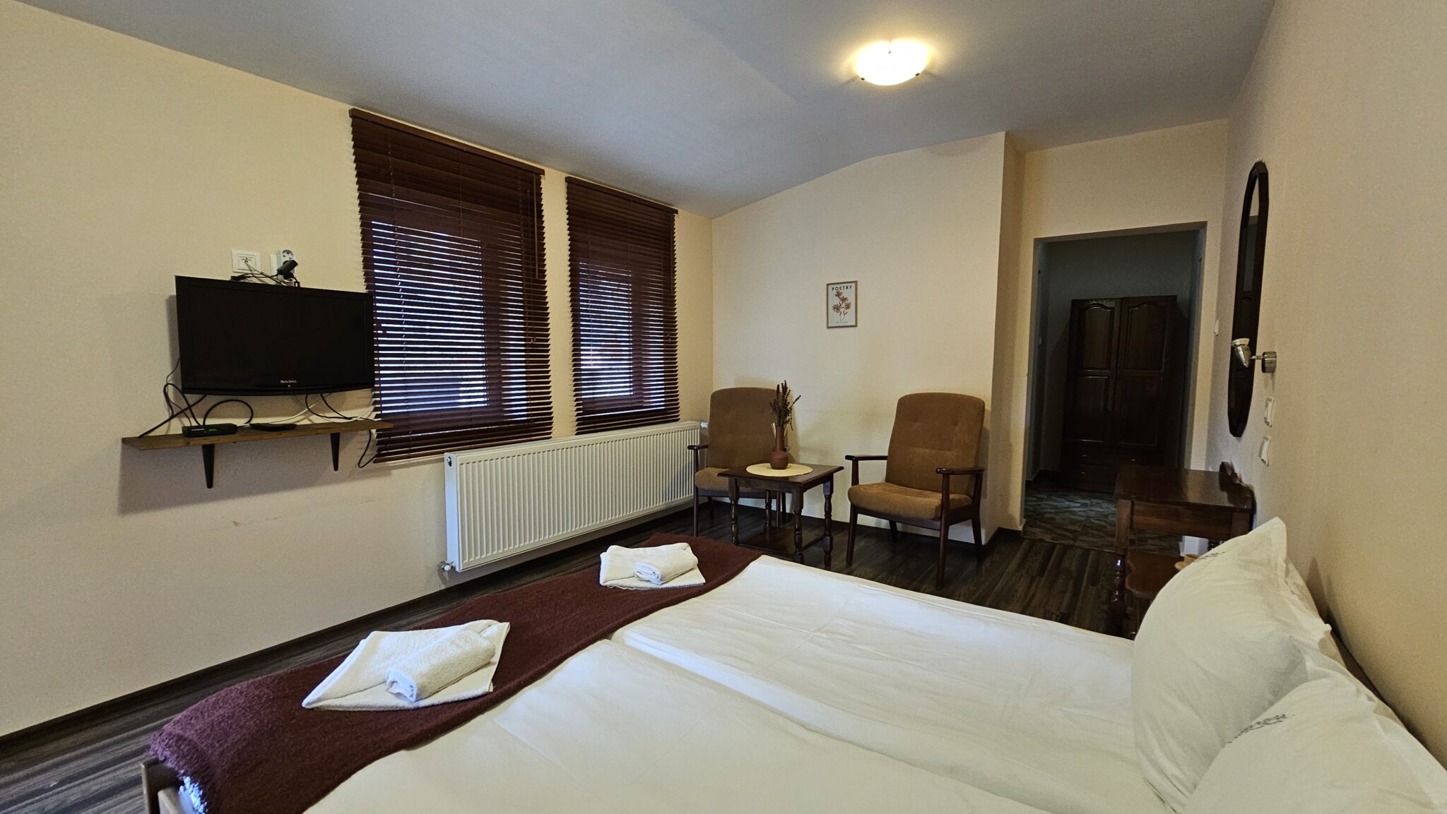 The television facing the bed and the armchairs by the windows