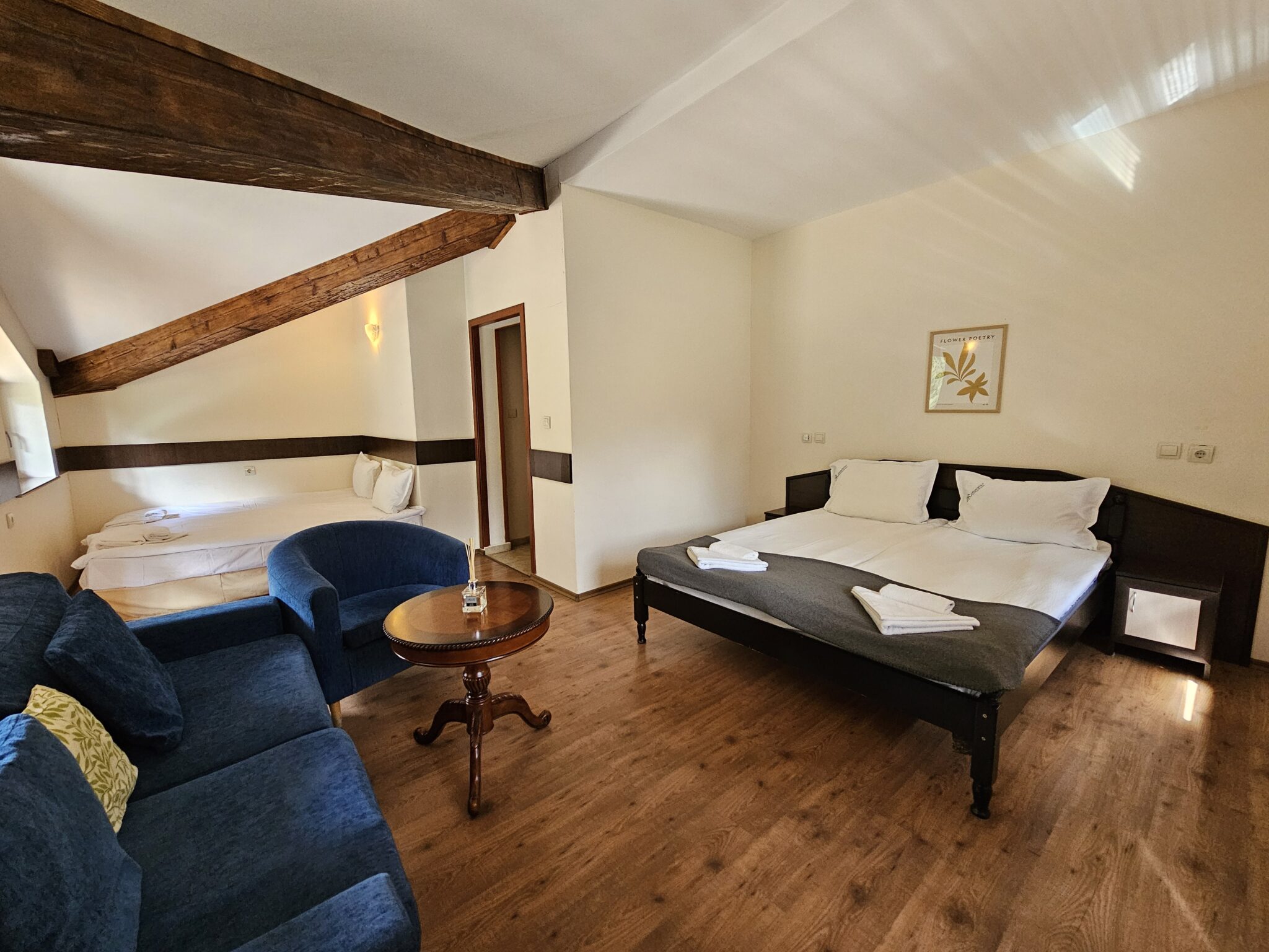 The double bed under the sloping ceiling and the blue seating corner