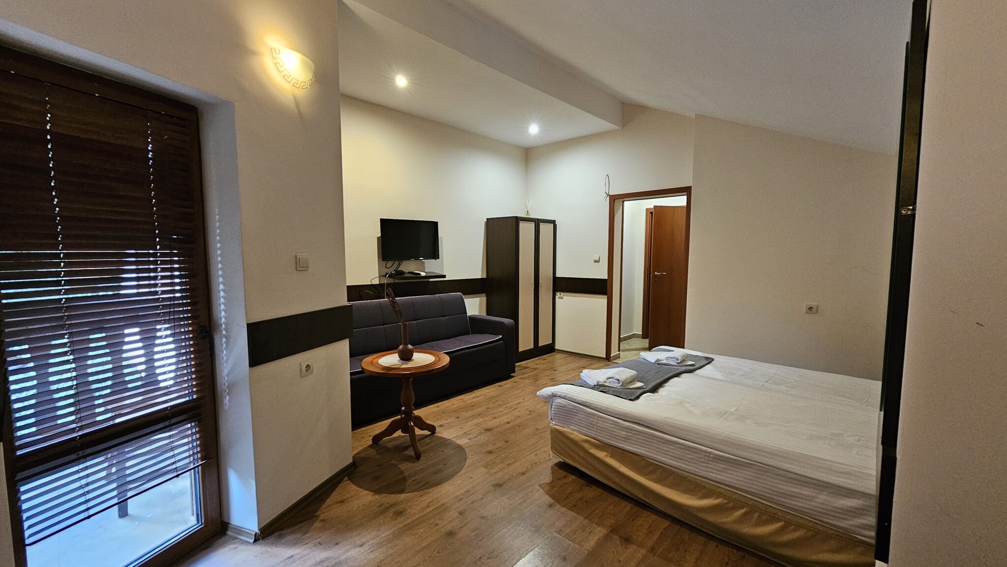 The sofa, television and wardrobe, with the bed on the right