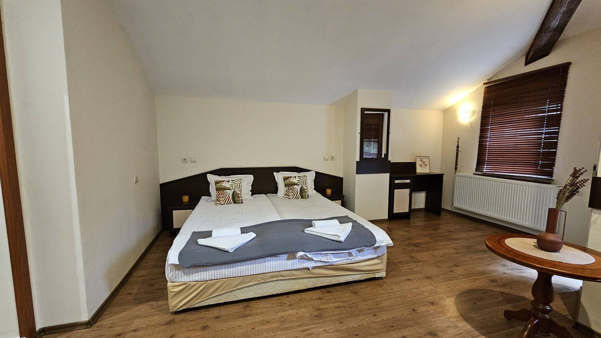 The double bed with a dressing table by the window