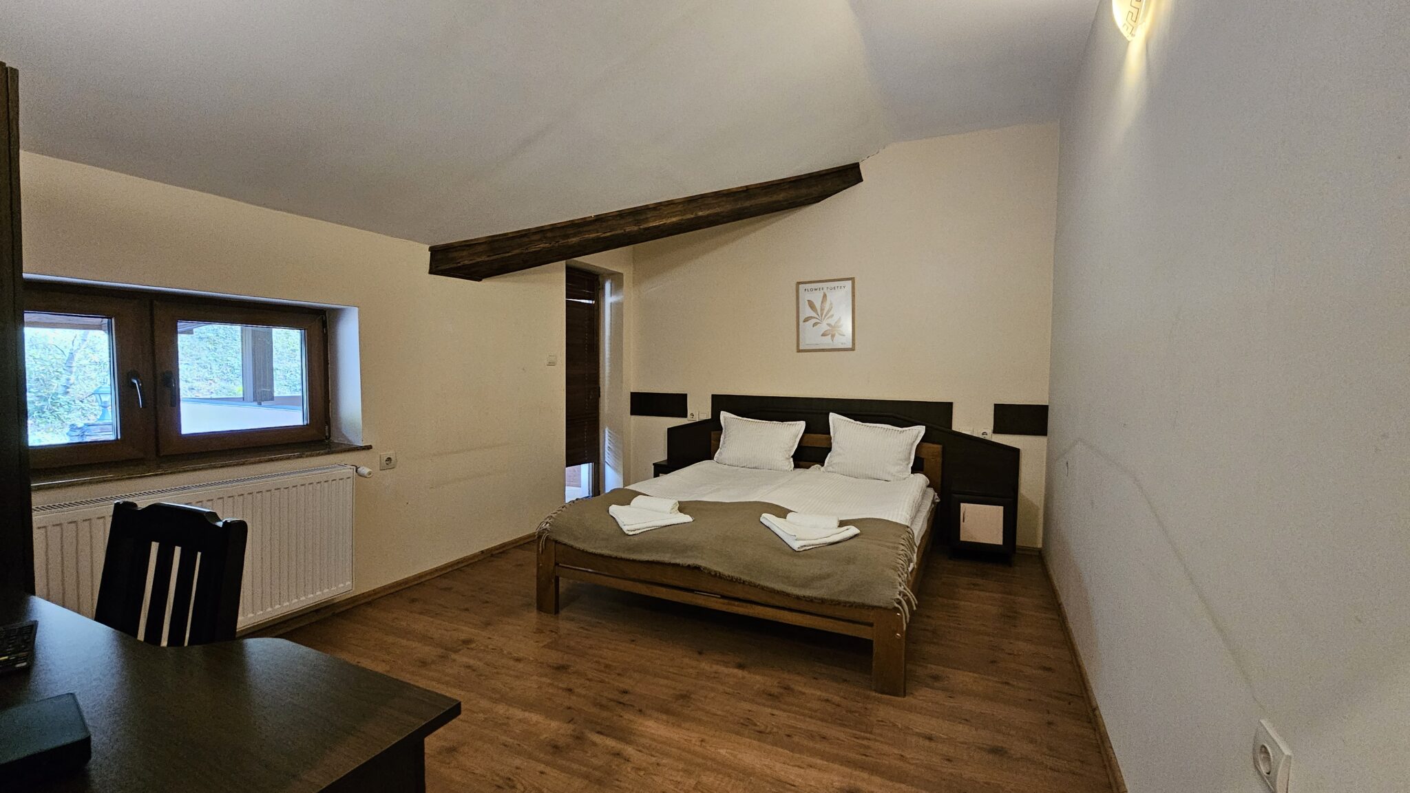 Double bed under the sloping ceiling, window on the left