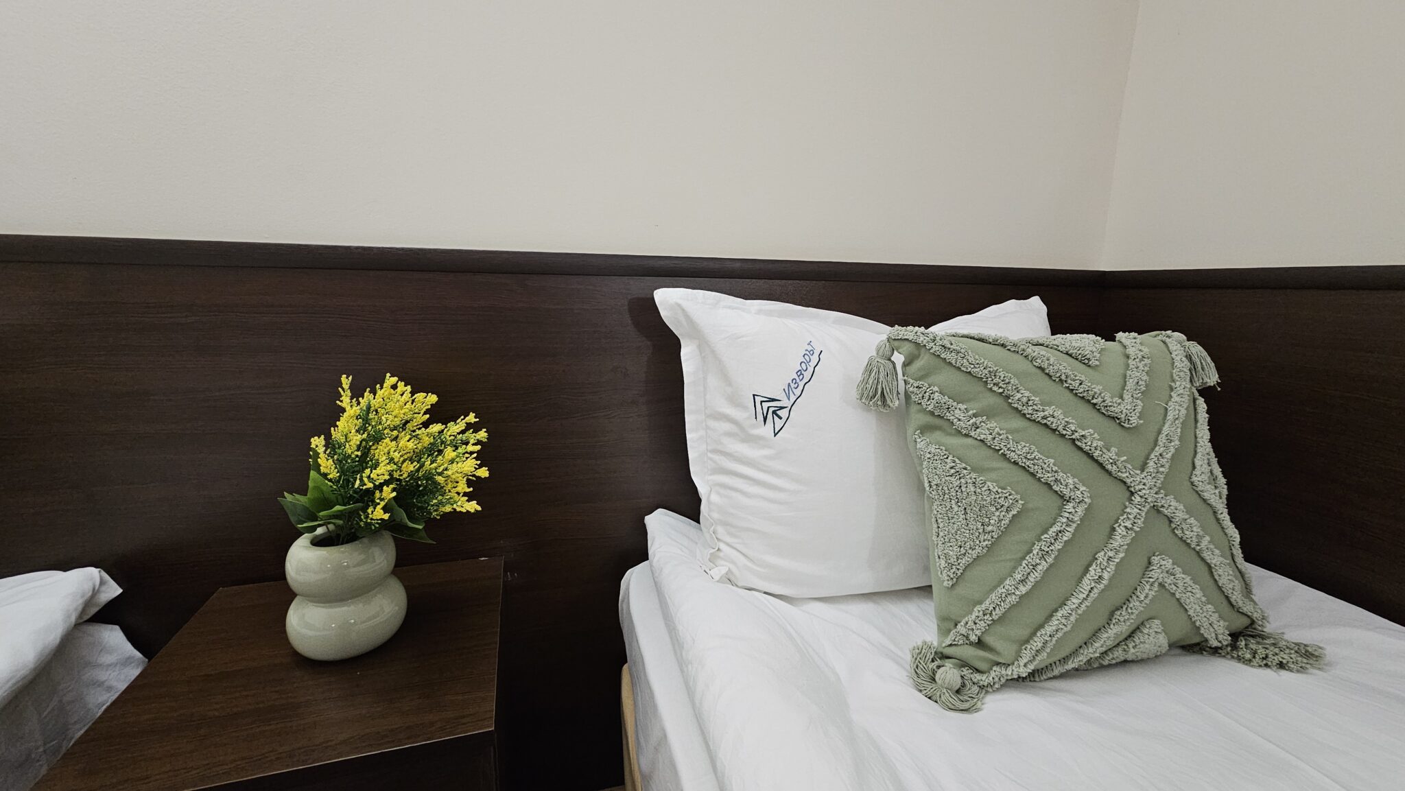 The pillows and the bedside table with flowers