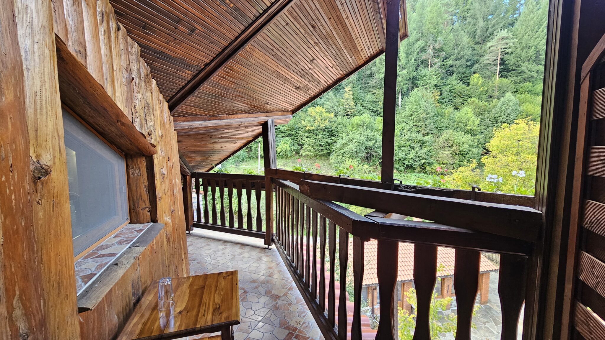 The covered balcony with a wooden ceiling and railing