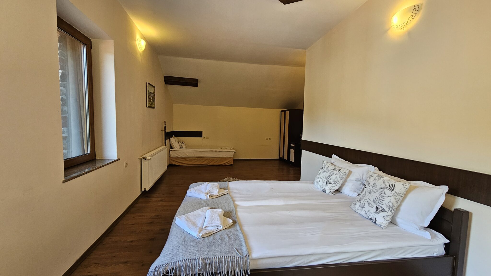 The double bed, with the single one behind by the window