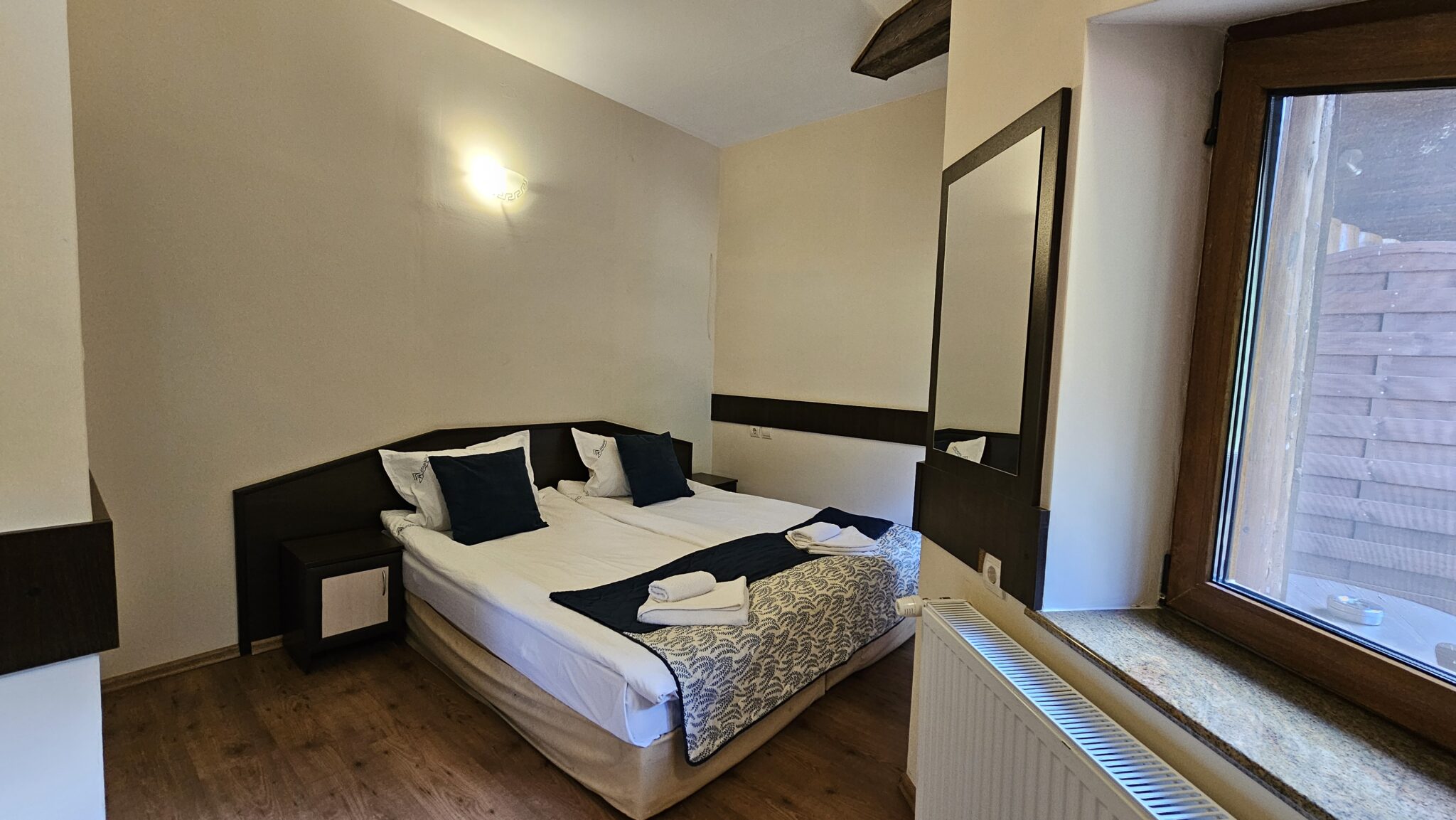 The bed and mirror in a warm-toned room