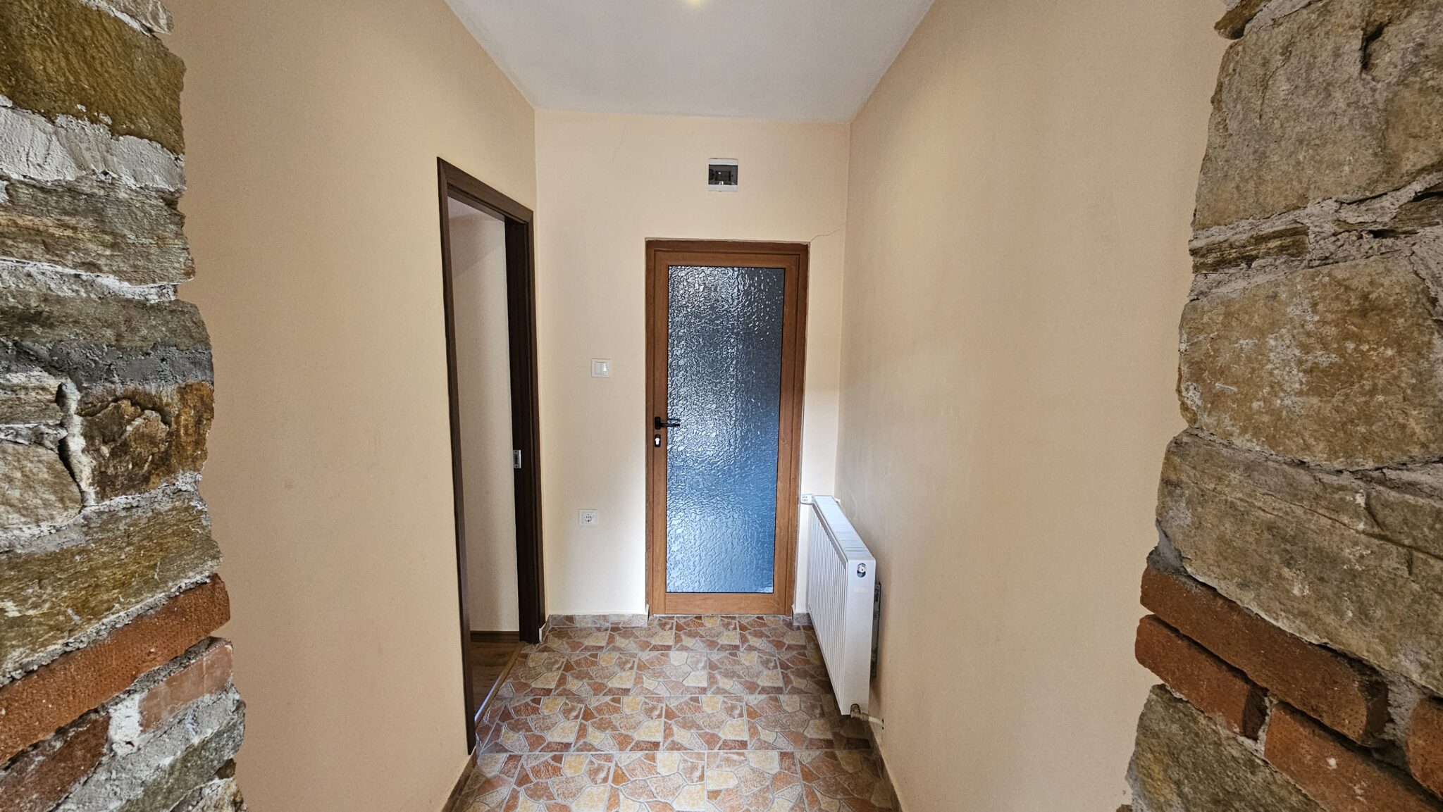 The corridor to the room, with an exposed stone wall
