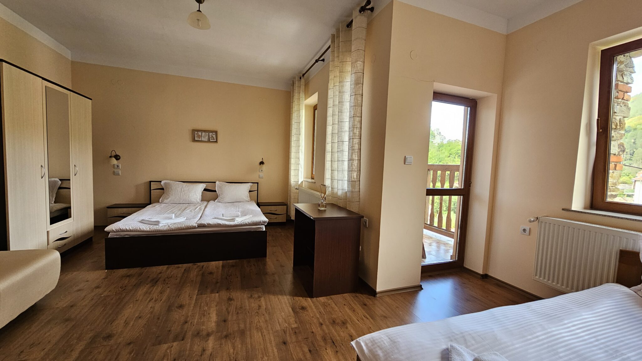 Double bed, chest of drawers and the balcony door